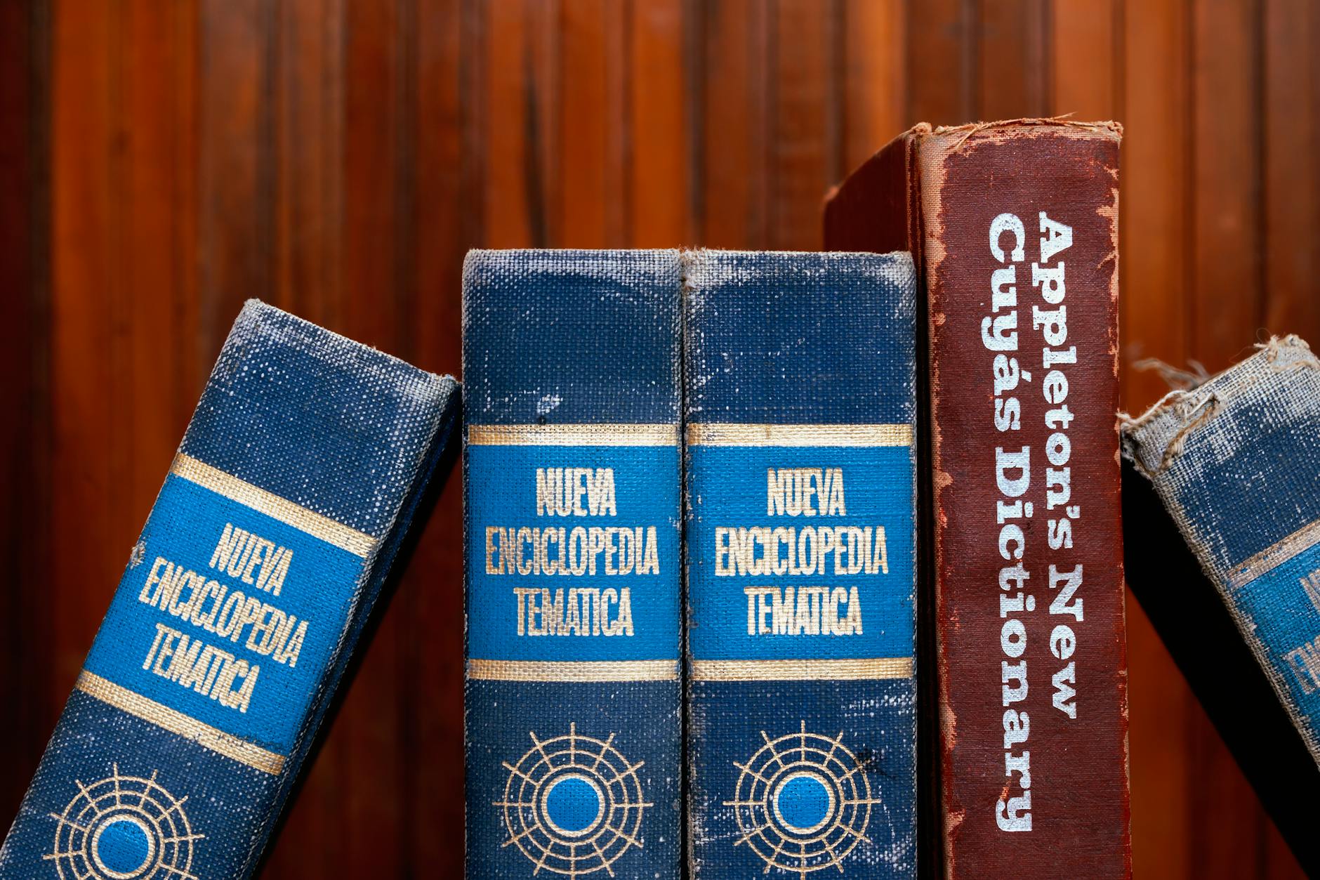 three books on a shelf with a wooden background